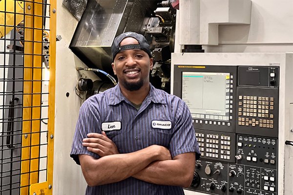 Machine operator standing near CNC machine